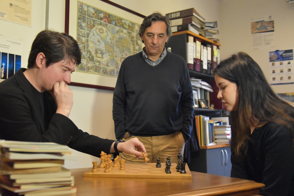 Una partida de ajedrez entre Claudia y Camilo es observada por el Dr. Eugenio Yáñez, director de la Escuela de Humanidades USS.
